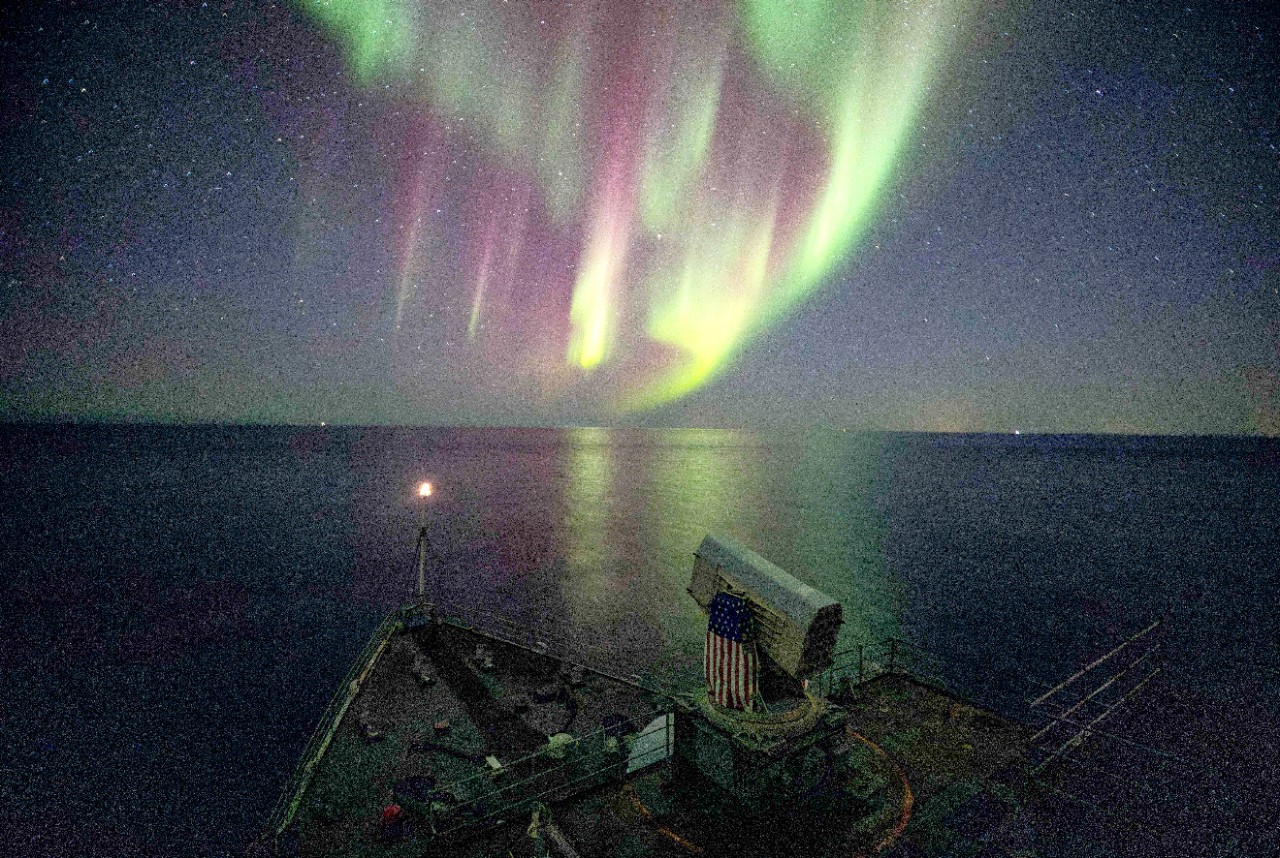 The Whidbey Island-class dock landing ship USS Gunston Hall (LSD 44) passes under the northern lights