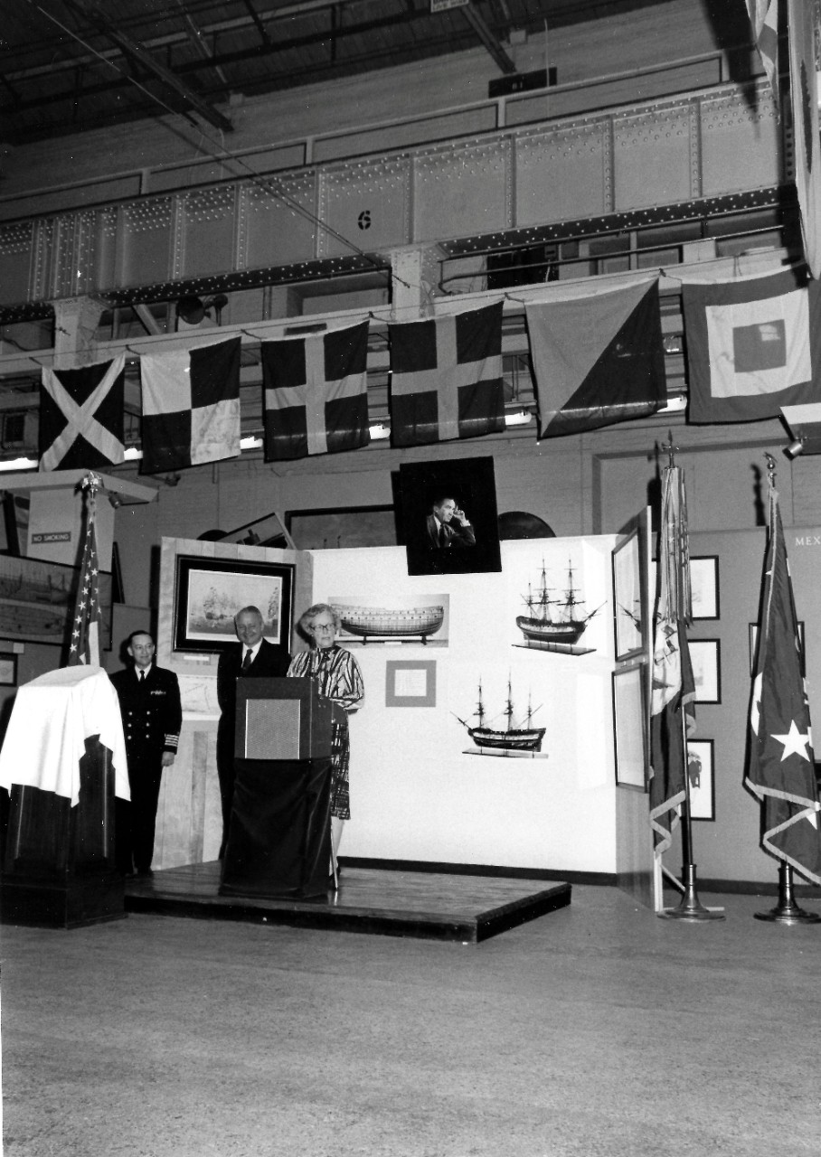 NMUSN-137: Presentation of HMS Intrepid Silver Tray, April 1975. Shown: Mrs. Edward R. Murrow gives remarks while Navy Memorial Museum Director, Captain Roger Pineau, far left, and Secretary of the Navy J. William Middendorf look on at the Navy M...