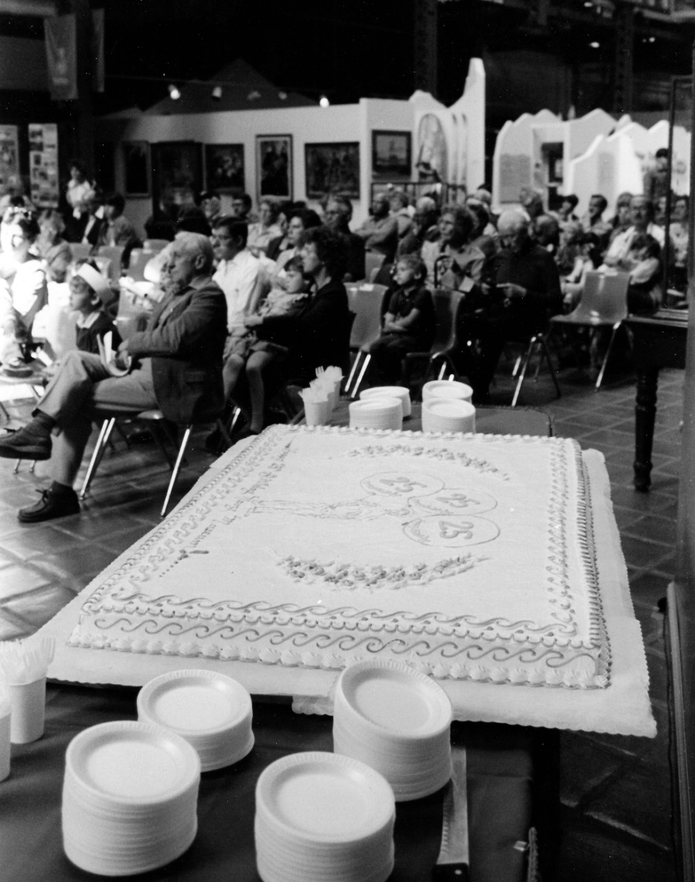 NMUSN-40: Cake for the 25th Anniversary of the Navy Museum, October 1987. Visitors listen to remarks at the Navy Museum, Washington Navy Yard, Washington, D.C. National Museum of the U.S. Navy Photograph Collection.