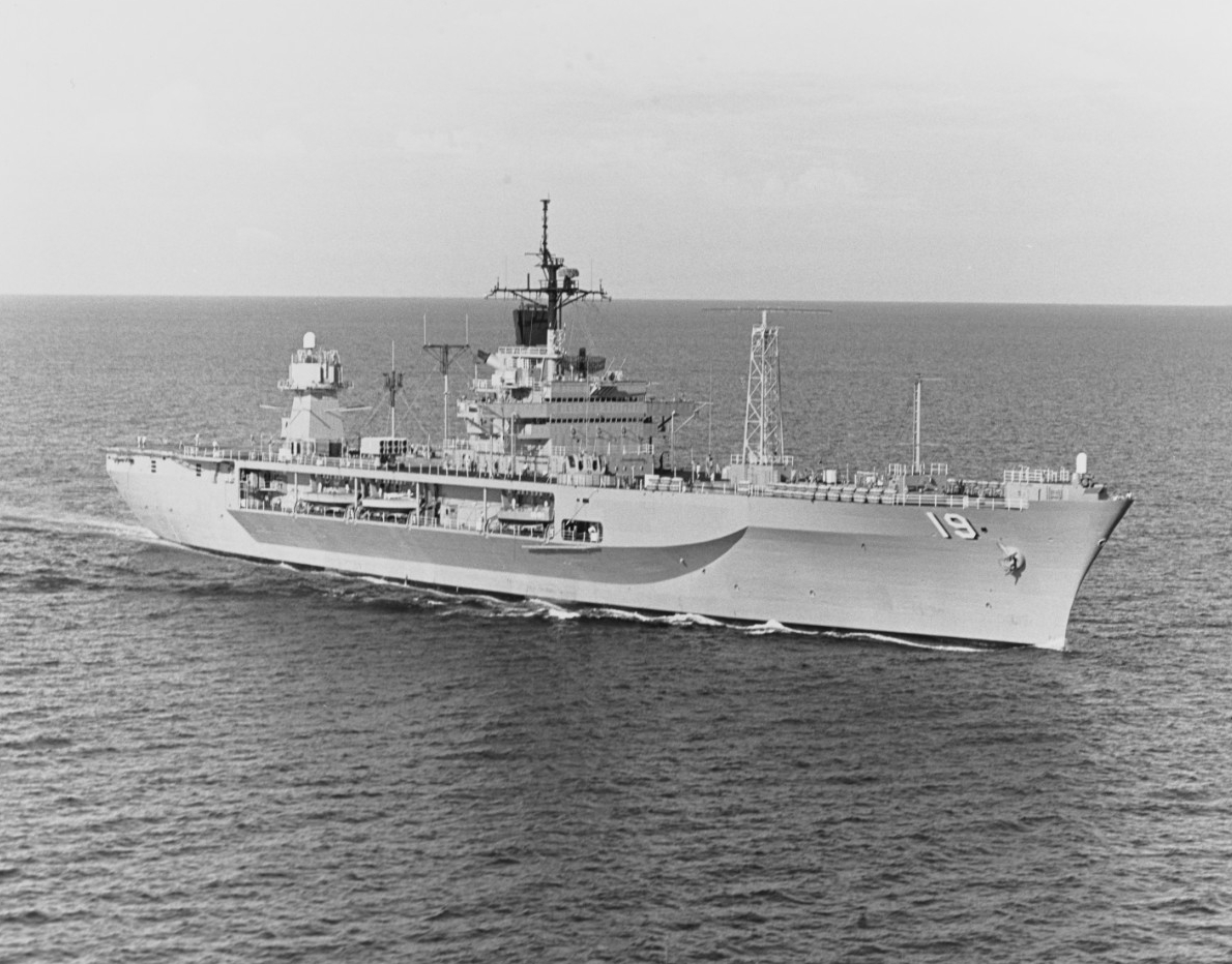Black-and-white photograph of USS Blue Ridge (LLC-19) steaming forward, bow to the right, on opean ocean. The ship’s hull number, 19, is clearly visible on the port side.