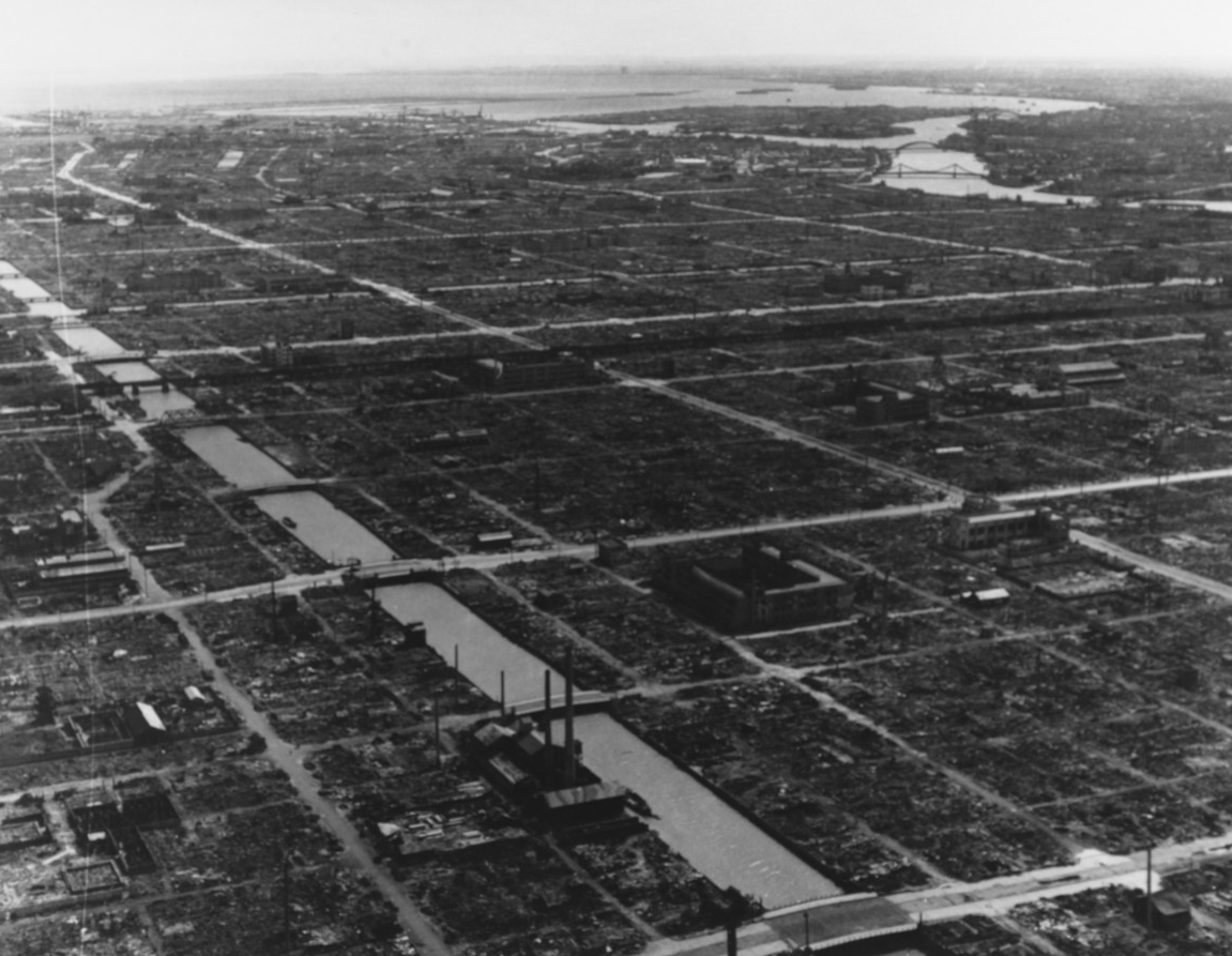 Black-and-white aerial photograph of a flattened city, Tokyo, but with canals and streets already cleared.