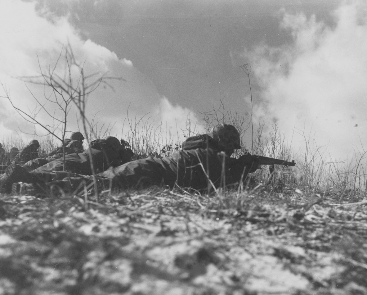 Marines lying on ground with guns