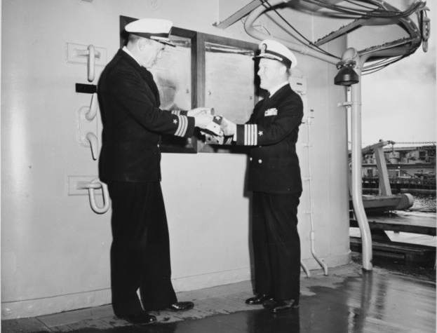 USS Baltimore (CA-68) commanding officer, Captain Scarritt Adams (right), receiving her commissioning pennant from his executive officer, Commander G.M. Boyd, following her final decommissioning ceremonies.