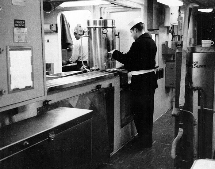 A crewmember draws a cup of coffee, in the crew's messing spaces, 1967.