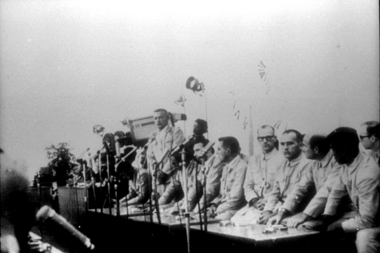 Poor quality photograph of USS Pueblo (AGER-2) crewmembers at a press conference in North Korea. Click image to download.