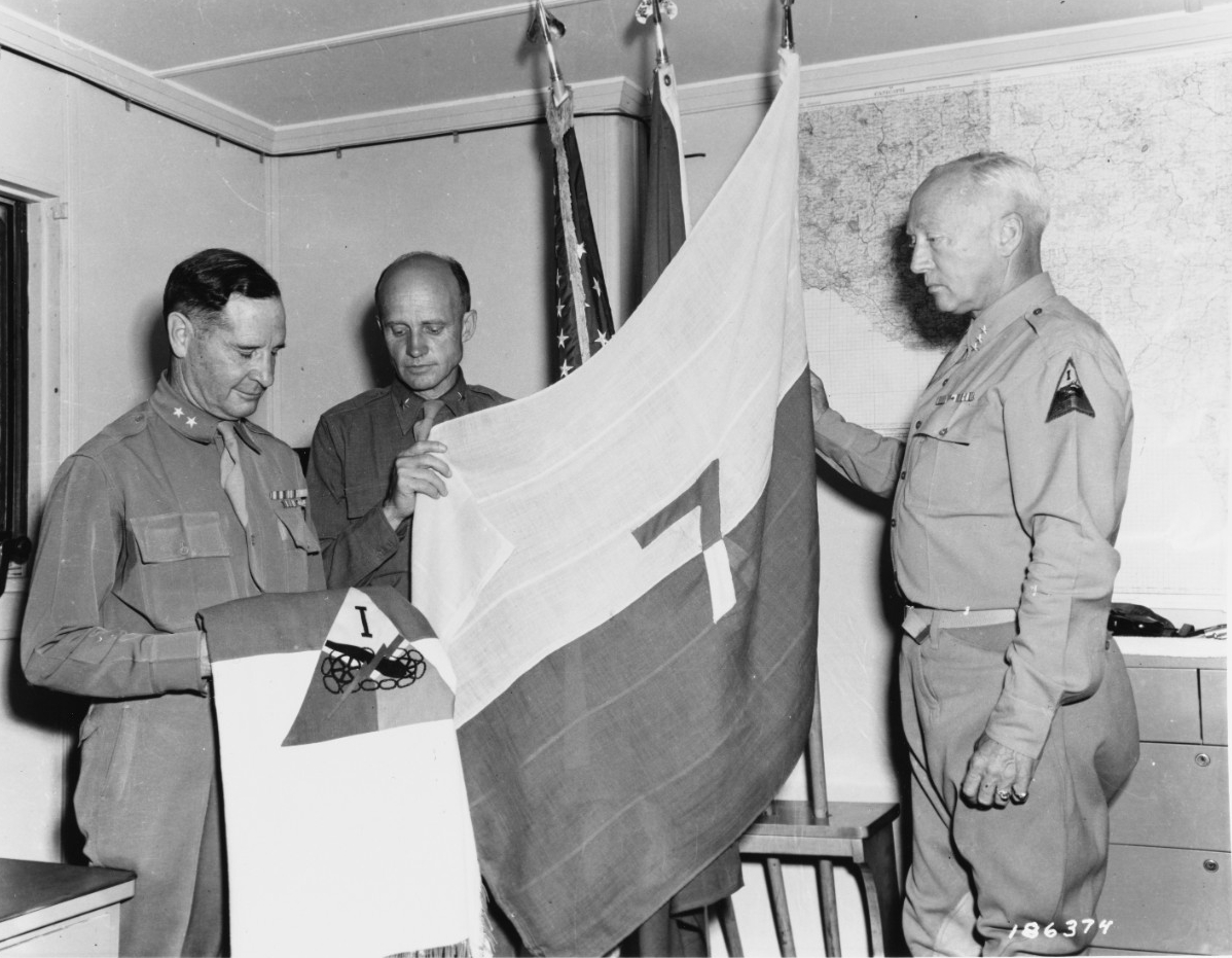 Sicily Invasion, July 1943. Major General Geoffrey Keyes, Brigadier General Hobart Gay, Lieutenant General George S. Patton, CG, 7th Army examining a 7th Army flag.