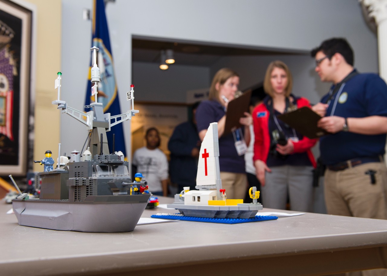 Judges examine an entry during the Brick-by-Brick Lego Shipbuilding Competition at the Hampton Roads Naval Museum.