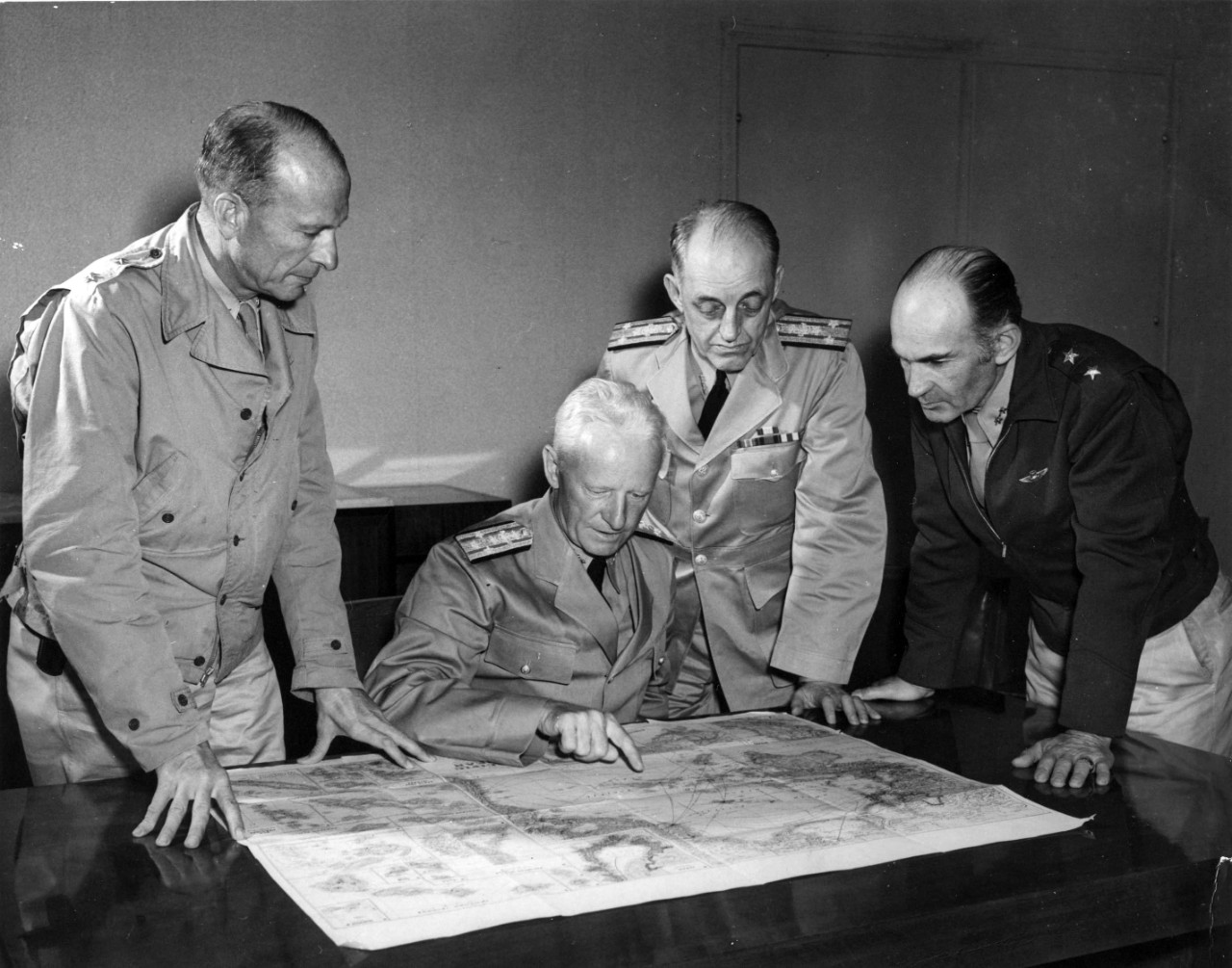 Admiral Chester W. Nimitz, USN, Commander in Chief Pacific Fleet and Pacific Ocean Areas confers with south Pacific area officers, possibly aboard USS Argonne (AG-31) at Noumea, New Caledonia, on 28 September 1942.