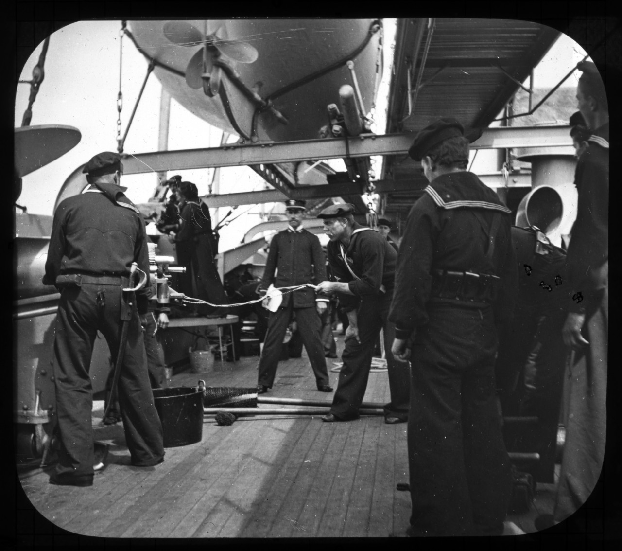 An undated photo shows Sailors of USS Charleston (C-2) manning one of the ship's guns during the Spanish-American War. Naval History and Heritage Command photo archives staff members are scanning a wooden box containing approximately 150 glass pl...