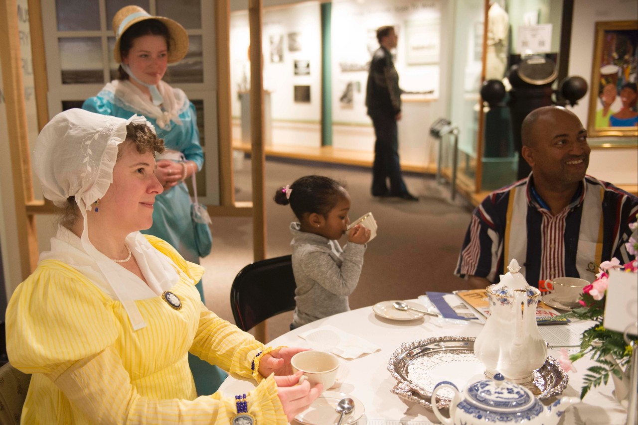 Period re-enactor Stacy Weissner, from the Virginia Regency Society, drinks tea with Leia Palmer, 3, during the Hampton Roads Naval Museum's tea party