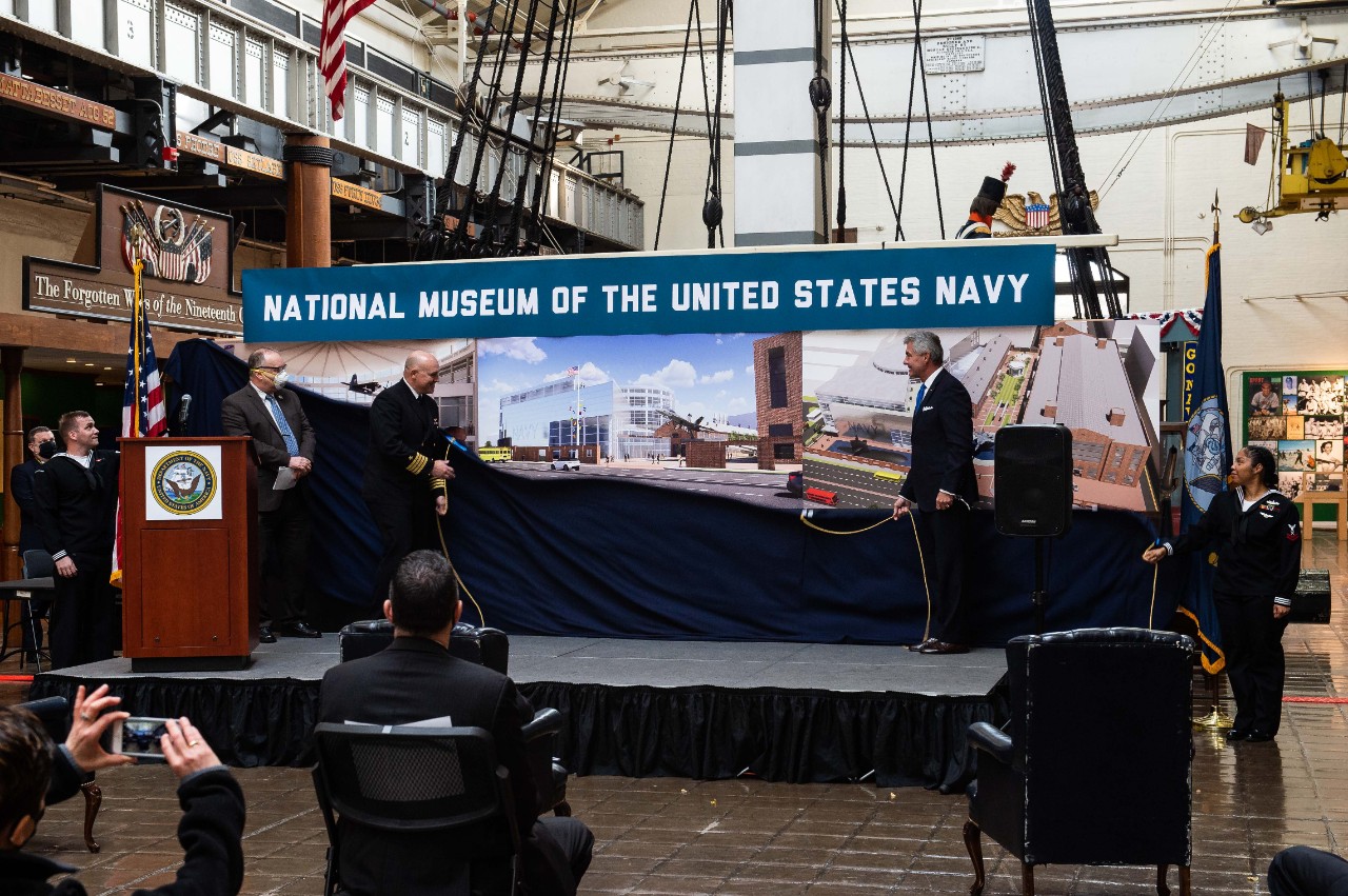 Secretary of the Navy, Kenneth J. Braithwaite and members of Naval History and Heritage Command (NHHC) unveil renderings of the future National Museum of the United States Navy (NMUSN) during the announcement ceremony of the new NMUSN. To honor t...