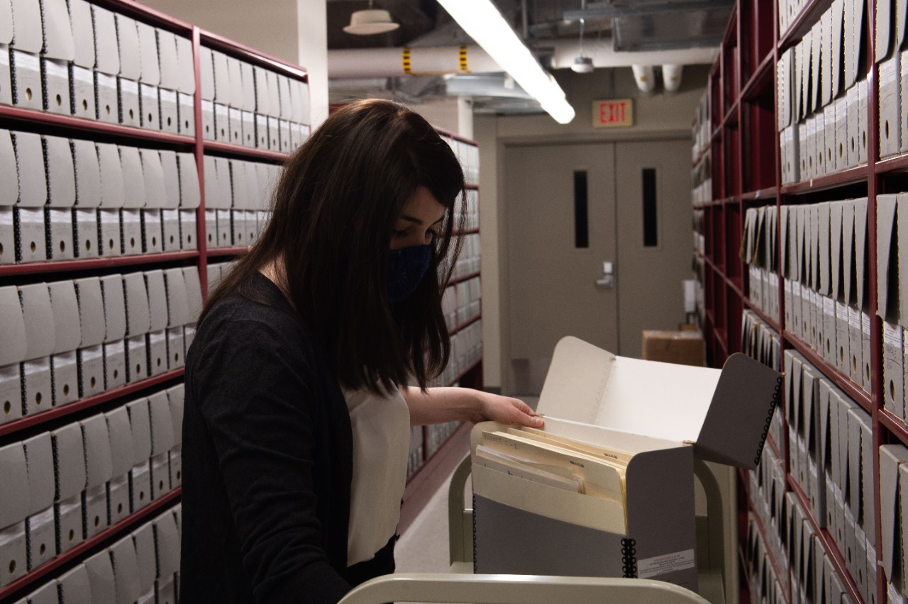 Amara Pugens, an archivist at Naval History and Heritage Command (NHHC) files away a command operations report (COR). The Chief of Naval Operations-mandated CORs are yearly summaries of a command's operations and major achievements permanently ar...