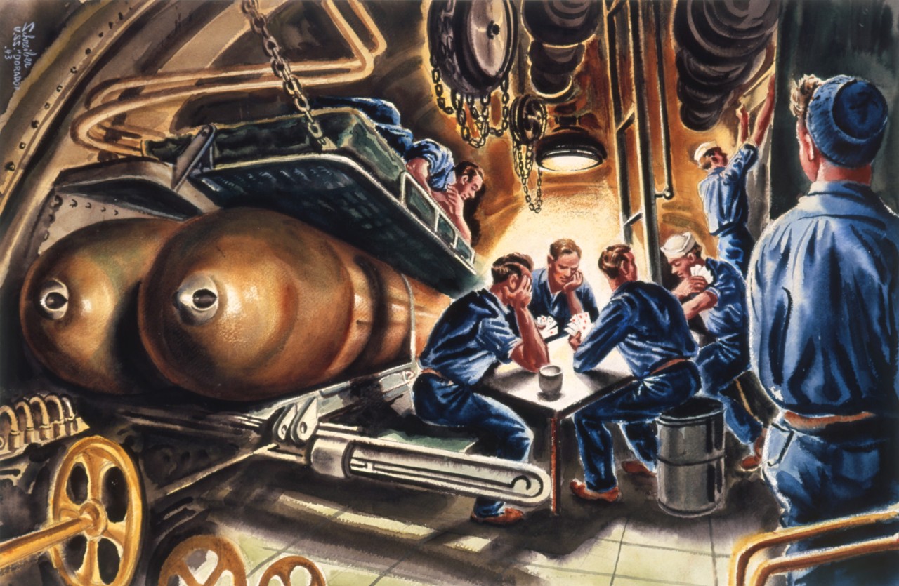 Sailors at a table relaxing they are next to two torpedoes