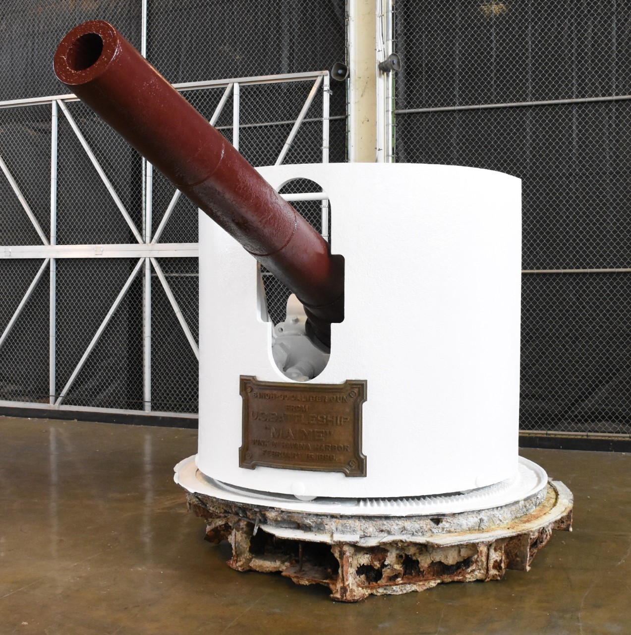 6-inch gun recovered from the wreck of the USS Maine in 1911. Gun has maroon barrel with white shield.