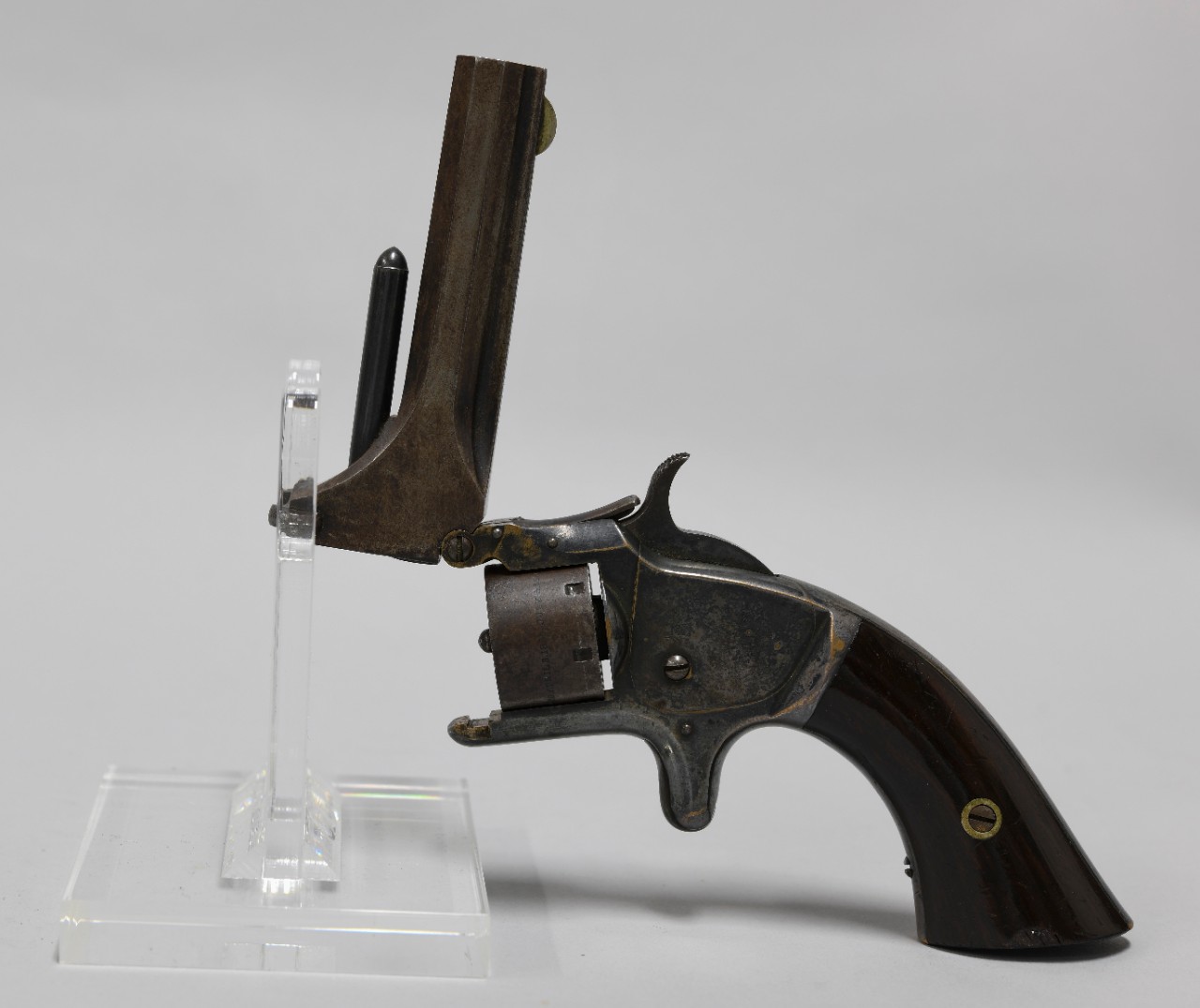 Reverse view of .22 caliber Model No. 1 Smith & Wesson bottom-break revolver. Metal frame with polished wood grip. Barrel opened.    