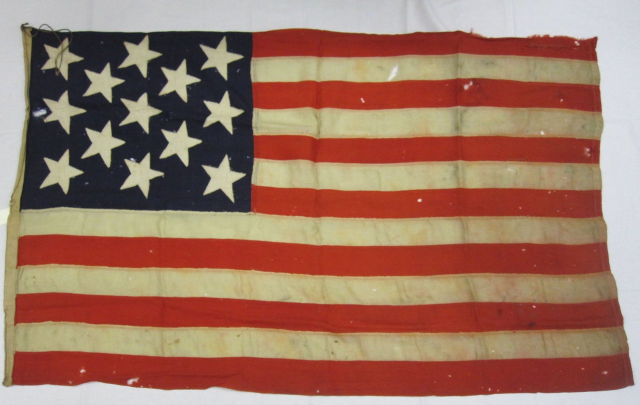 full view of Boat Flag from USS Olympia with 13 stars on a blue field and 13 stripes of red and white