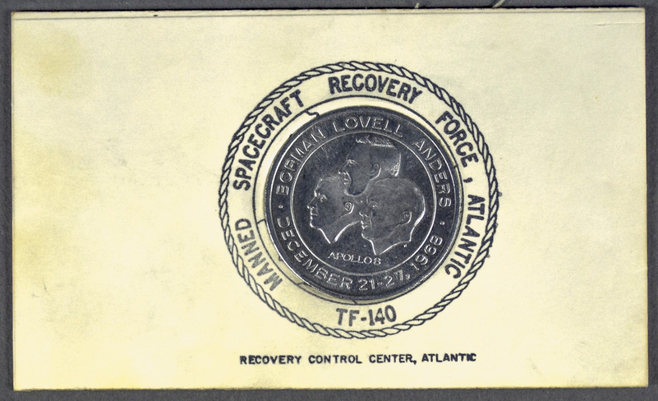 One commemorative coin from apollo 8 Recovery mounted on cardboard stamped with manned spacecraft recovery force atlantic