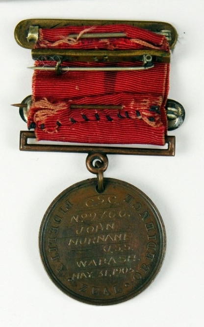 Reverse of medal showing diffferent devices on ribbon and engraved planchet