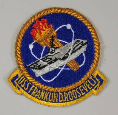 Patch with an aircraft carrier and a nuclear symbol and torch with USS Franklin D Roosevelt