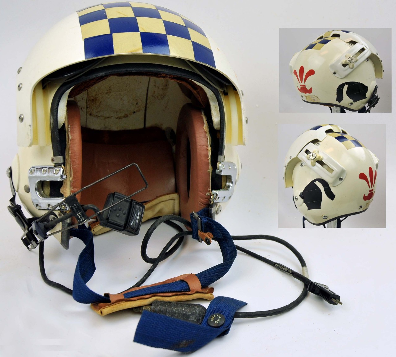 One white flight helmet. The top and visor of the helmet have a square patch of blue and yellow squares in a checkboard pattern. The visor is adjustable along a track with two adjustment hand wheels on either side of the helmet. The part of the h...