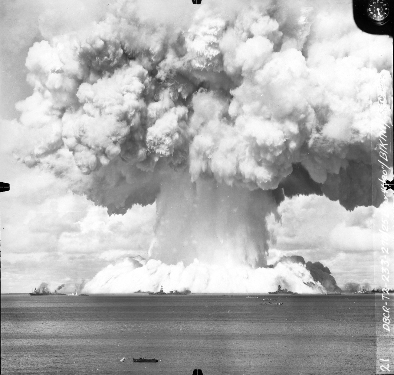 Collection of 38 photographs of the "Baker Day" atomic bomb explosion at Bikini Atoll, Marshall Islands, 25 July 1946. Received from OP-45 prior to 1985. These views are from three different series, one shot from the ground level and the other two taken from aircraft on opposite sides of the explosion site. A full contents listing is below. 