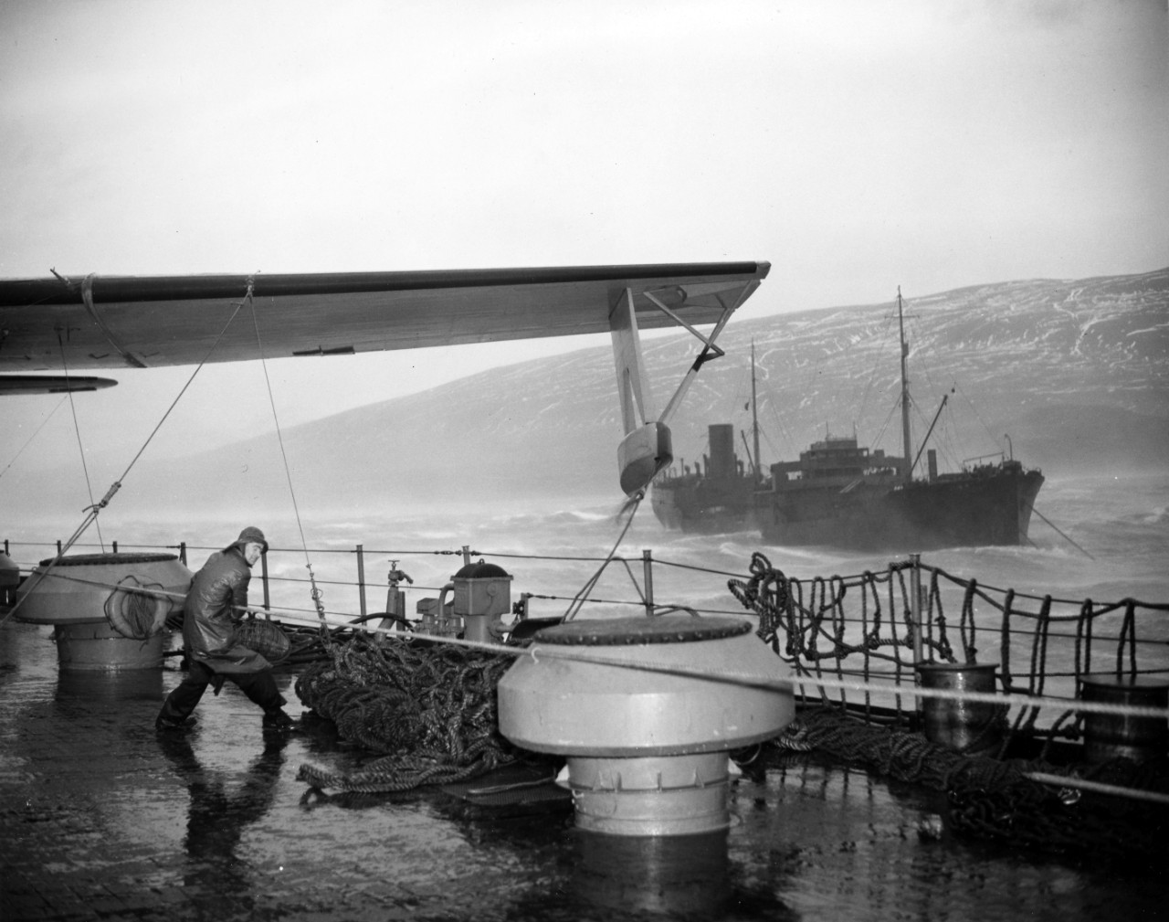 The crew of a seaplane tender struggling to secure seaplanes during a storm off the coast of Hvalfjordur, Iceland. From the VADM Robert C. Giffen Photo Collection.