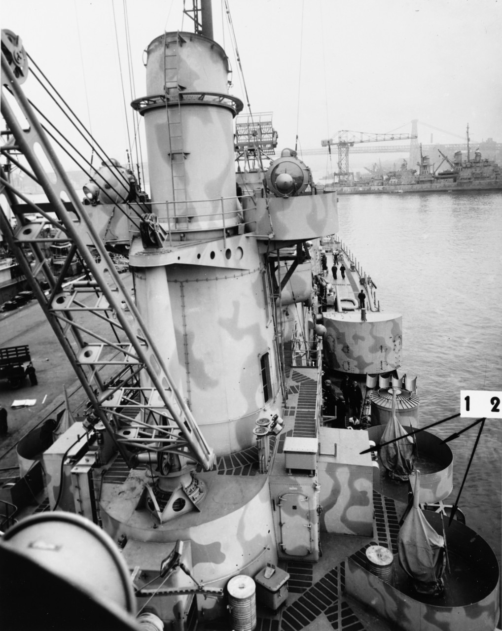 USS Juneau (CL-52) at the New York Navy Yard, 19 March 1942. Arrows mark recent alterations. Note details of boat crane.