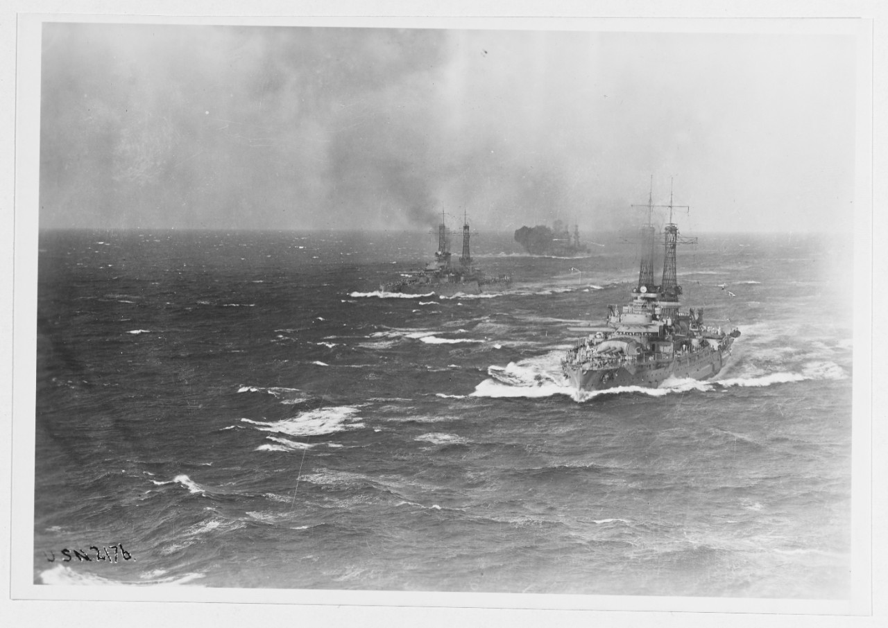 Distant view of battleship squadron at sea in 1921.