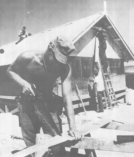 Image of Navy SEABEE Saws Wood as Other MCB-4 Men Work on New Living Quarters at Air Strip Being Constructed at Chu Lai, South Vietnam