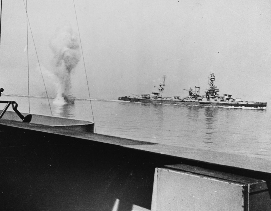 The German gunners at Marine-Küsten-Batterie Hamburg fight indomitably and fire this 11-inch round that splashes dangerously close to Arkansas (foreground) and Texas (background), 25 June 1944. Photographed from Arkansas. (U.S. Navy Photograph 80...