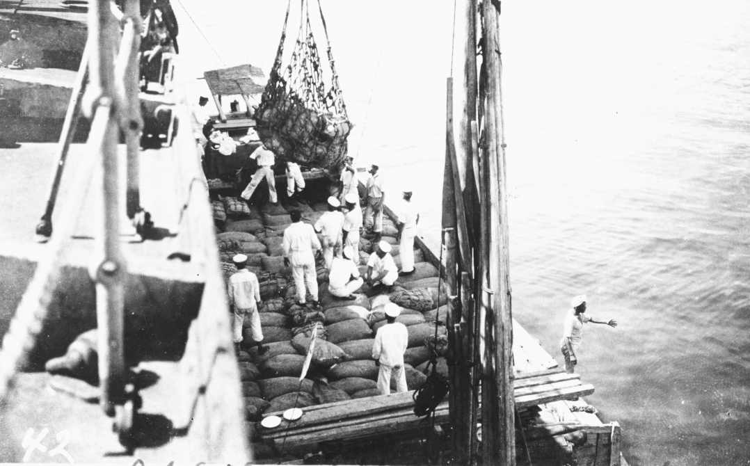 Japanese sailors help unload Black Hawk after her arrival in Tokyo Bay with relief supplies for victims of the great earthquake of September 1923. (Naval History and Heritage Command Photograph NH 100371)