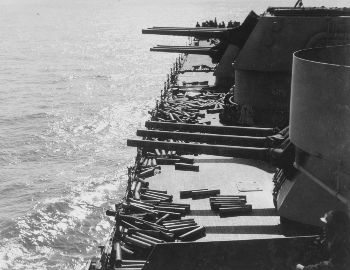 Empty shell casings litter Brooklyn’s deck near the ship’s forward 6-inch turrets as she blasts German and Italian soldiers during the landings at Licata, Sicily, 10 July 1943. (U.S. Navy Photograph 80-G-42522, National Archives and Records Admin...