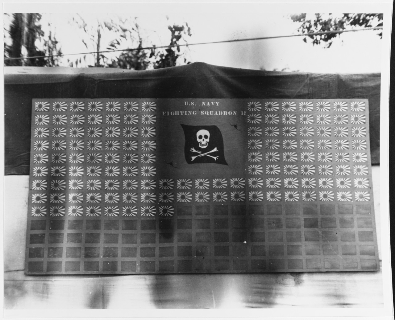 The men of VF-17 keep a scoreboard on Bougainville of their “kills,” which in this photo shows their claim of splashing 130 enemy planes, circa February 1944. The fighter pilots score all of these victories over the Solomon Islands, in November 1...