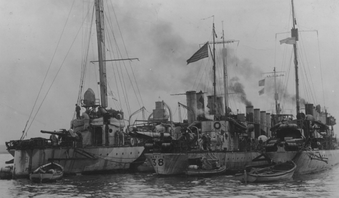 Destroyers Little (Destroyer No. 79), Jarvis (Destroyer No. 38), and Burrows, lying (L-R) in the inner harbor ready for convoy service, Brest, France, 27 October 1918, in this image captured by a Pvt. Barnes of the U.S. Army Signal Corps. Note weathered paintwork and details of depth charge tracks on board all three ships. Little carries her identification number in low-contrast camouflage paint, the configuration of her stern requiring the numerals to be painted on each side, whereas Jarvis’ identification number is painted across her rounded stern just beneath the name JARVIS. Also note Burrows’ badly damaged starboard propeller guard (R). (U.S. Army Signal Corps Photograph 111-SC-30973, National Archives and Records Administration, Still Pictures Branch, College Park, Md.)