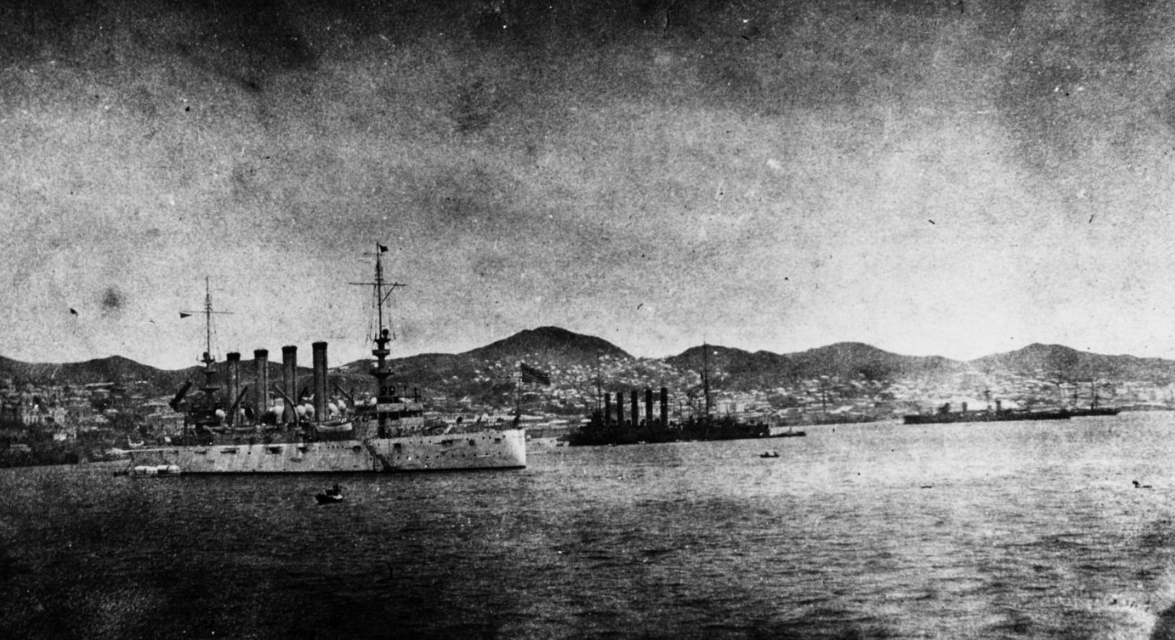 Charleston drops anchor near (left–right) Russian protected cruisers Askold and Zhemchug during her visit to Vladivostok, Russia, 22–26 June 1909. The officers and men of the three ships amicably exchanged greetings, but German light cruiser Emde...