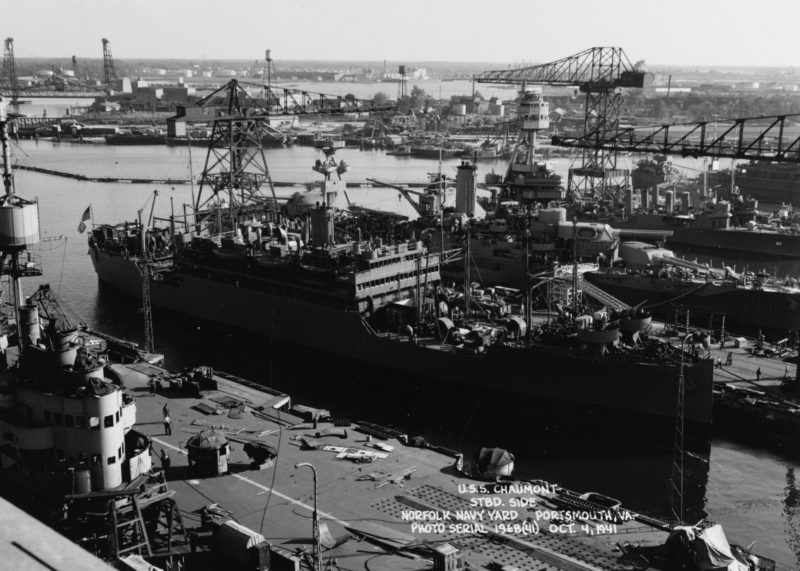 Chaumont at the Norfolk Navy Yard, 4 October 1941. Texas (BB-35) is in the background to the right with Dickerson (DD-157) and another flush-decker. The British aircraft carrier in the foreground is HMS Illustrious, under repair under Aid Short o...