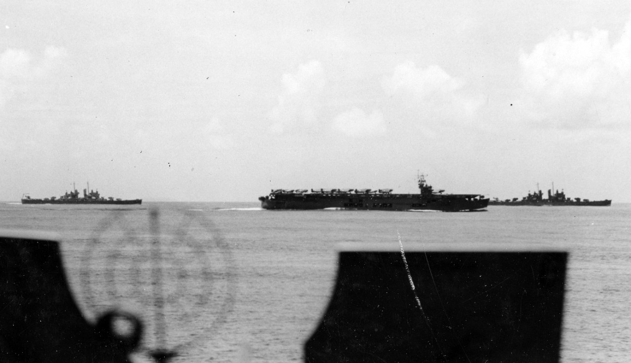 Cleveland (left), either auxiliary carrier Suwanee or Chenango (ACV-28) (middle), and light cruiser Montpelier (CL-57) (right) steaming in formation with Task Force 18, 29 January 1943. The photograph was taken from heavy cruiser Wichita (CA-45)....