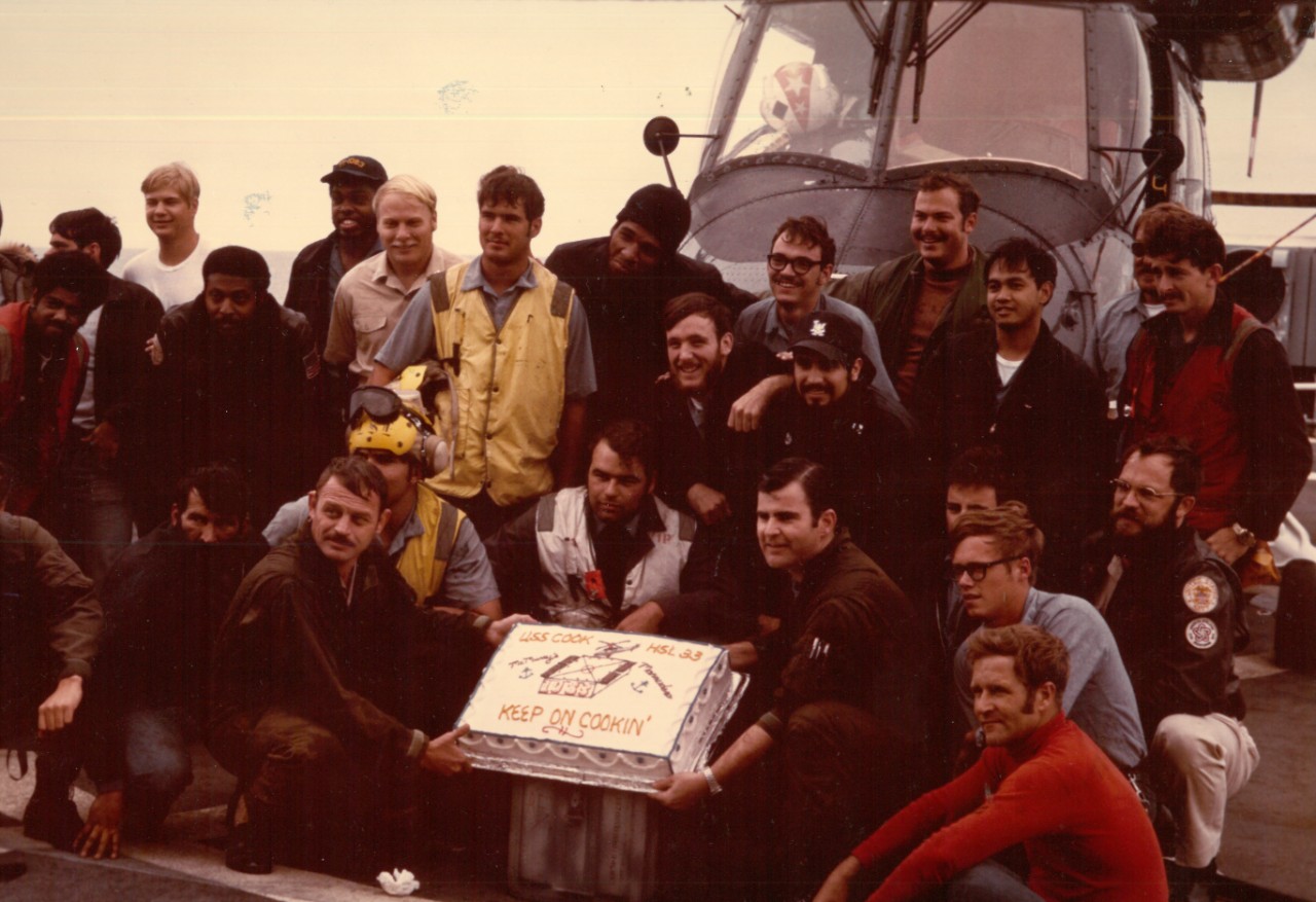 Members of HSL 33, Det. 8 celebrate 1,083 safe landings on board Cook, 22 December 1976. (NHHC Archives)