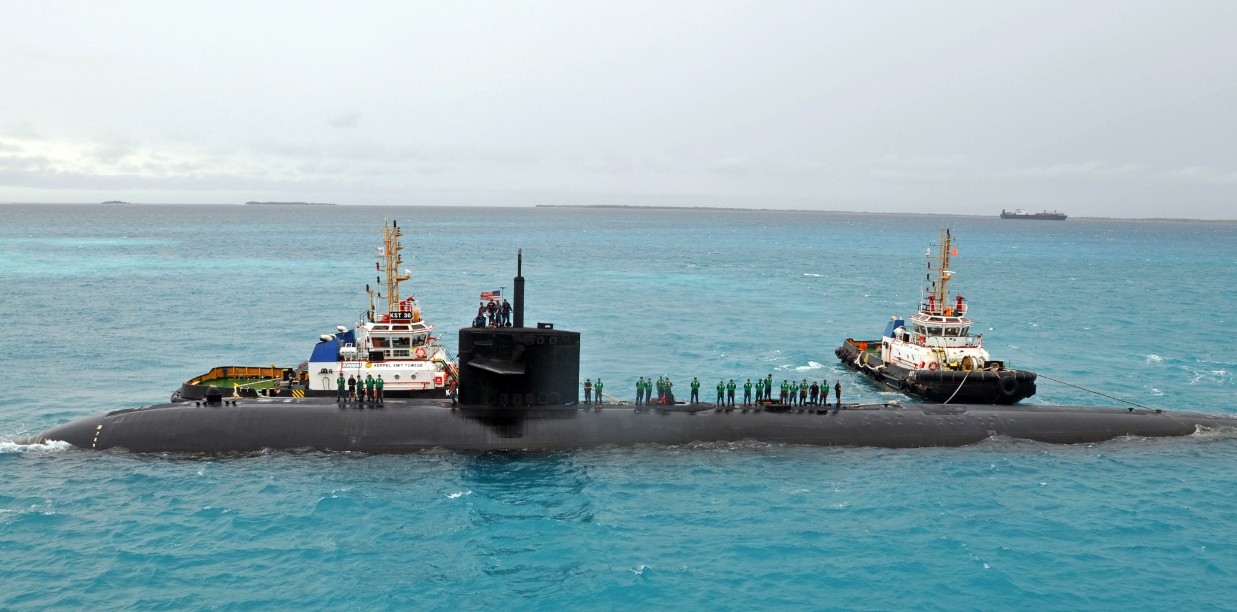 Tugs nose Dallas toward Emory S. Land (AS-39) at Diego Garcia, British Indian Ocean Territory, 8 September 2011. The attack boat is on a deployment to the Indian Ocean and begins voyage repairs and upkeep alongside the submarine tender. (MC2 Eliz...
