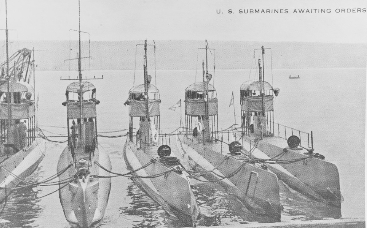 U.S. submarines awaiting orders. Halftone reproduction, printed on a postal card, of a photograph of five submarines nested together prior to World War I. The three boats at right are (from center to right): D-2 (Submarine No. 18); D-1 (Submarine...