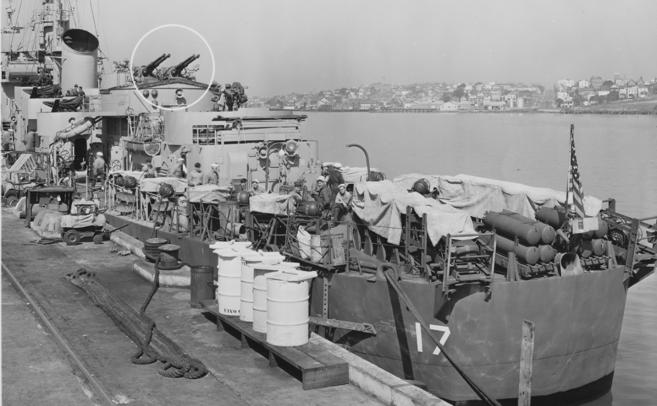 Edward C. Daly alongside a pier at Mare Island Navy Yard, 3 March 1945, shortly before her departure for the Pacific Theater. The circle is to indicate the quadruple 40-millimeter mount installed during the recently concluded overhaul. Three sail...
