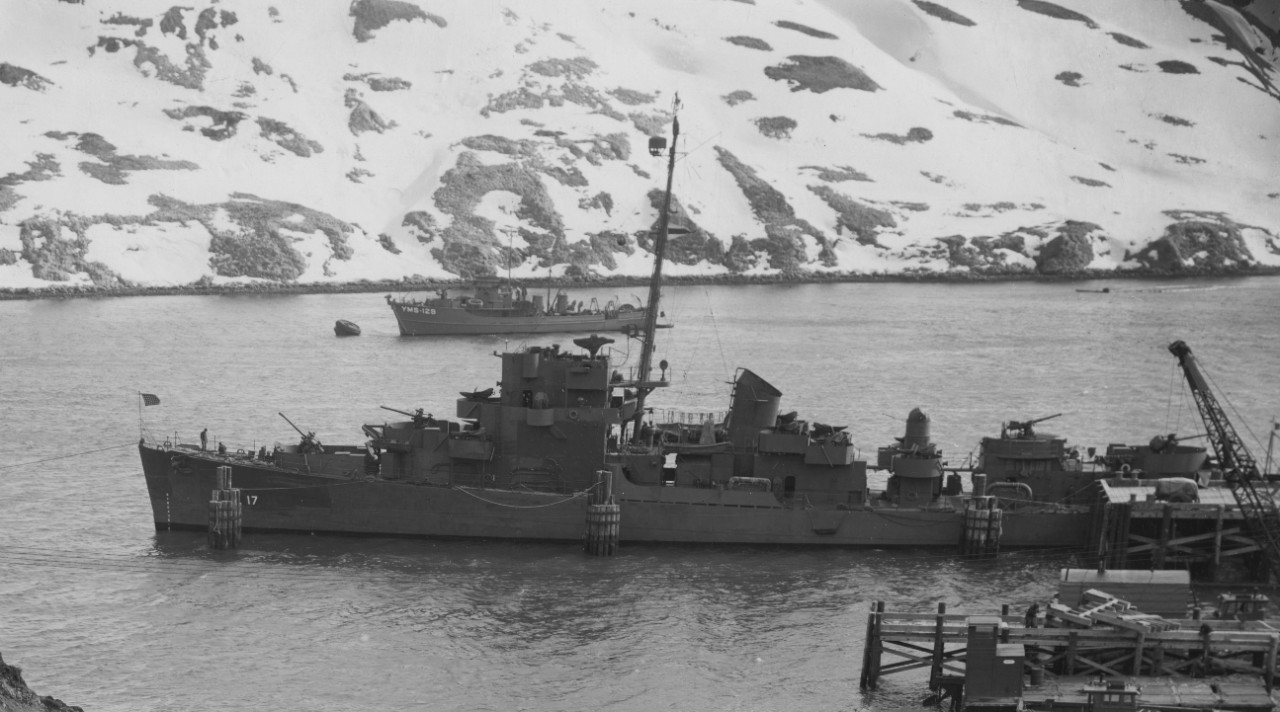 Edward C. Daly lies moored at Finger Bay, Adak, 3 March 1944. The motor minesweeper YMS-129 lies moored to a buoy in the background. (U.S. Navy Photograph 80-G-221595, National Archives and Records Administration, Still Pictures Division, College...
