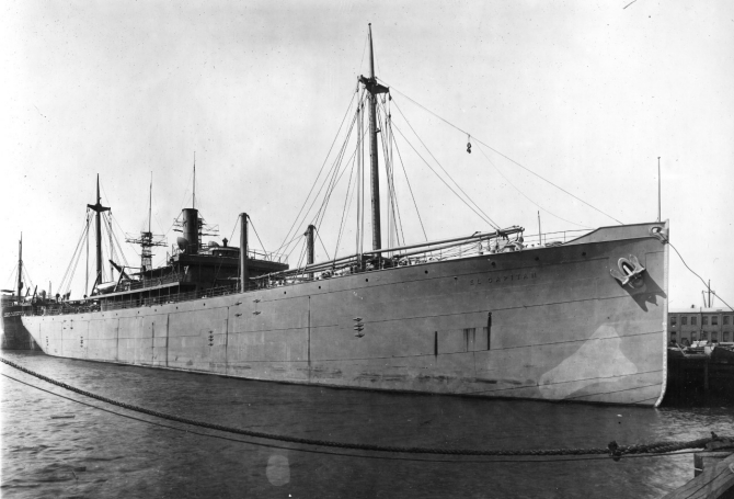 El Capitan, circa 1917, her name in raised letters on her bow, probably photographed at her building yard. Steamship Peter H. Crowell, moored astern, later served in the U.S. Navy, given the classification Id. No. 2987, and was commissioned on 20 December 1917. Note how El Capitan is riding high out of the water; she is drawing about 7 feet at this time. Also note the battleship masts in the background, visible beyond the freighter’s funnel. (19-LCM Collection, Box 615, National Archives and Records Administration, Still Pictures Branch, College Park, Md.).