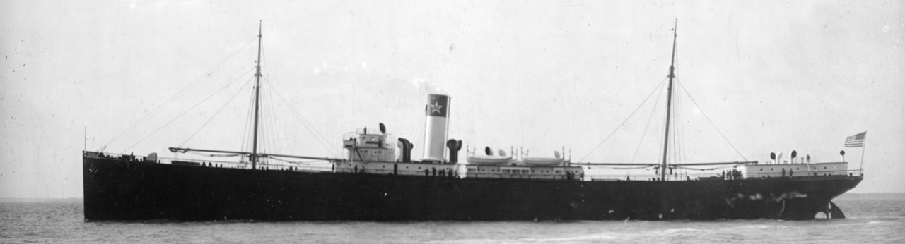 Undated view of El Occidente showing the ship in Hampton Roads as she appeared in merchant service. Note her clean uncluttered lines in this photo attributed to the Griffith Studio, and the colors above the fantail streaming in what appears to be...