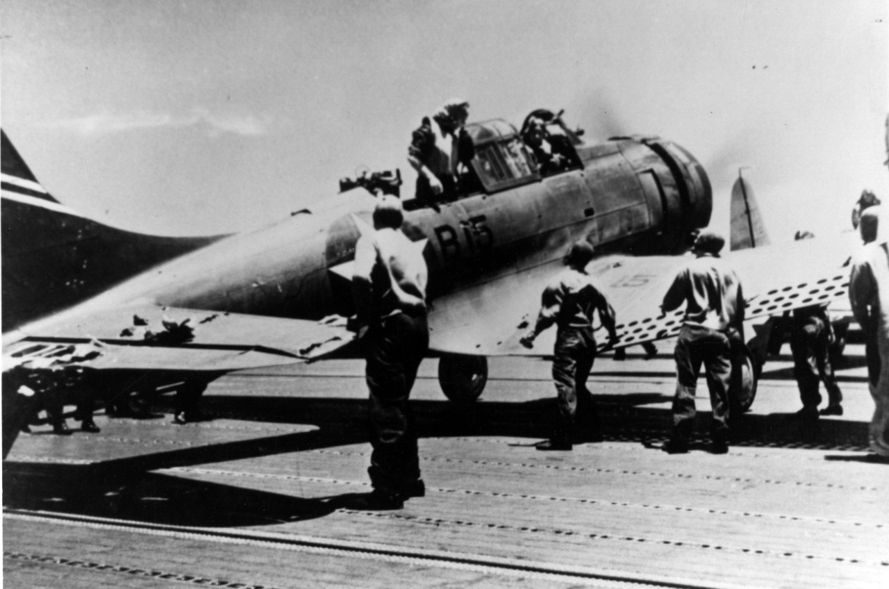 An SBD-3 (BuNo. 4542) of VB-6, Ens. George H. Goldsmith and ARM1c James W. Patterson Jr. -- still in the cockpit -- lands on Yorktown at about 1140 on 4 June 1942. The Dauntless is damaged (note the horizontal tail) while attacking Japanese aircr...