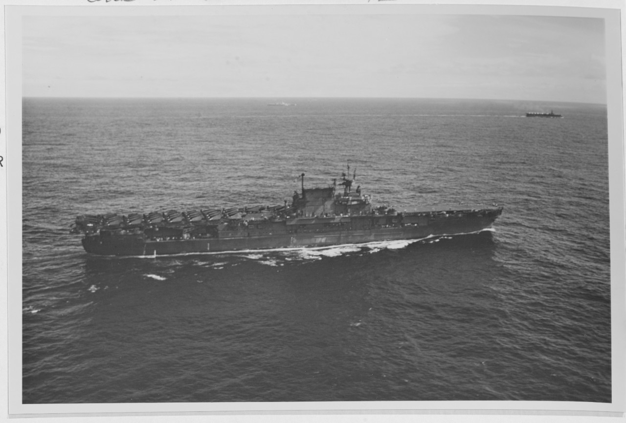 Planes with their wings folded pack the after half of the flight deck as Enterprise, the scars of war and long days at sea visible on her battered hull, makes for New York to take part in Navy Day, October 1945. The ship steams in company with Po...