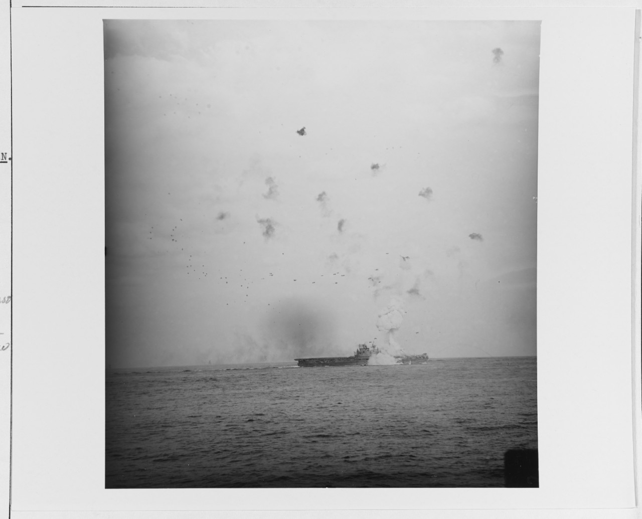 Despite the intense flak bursts over Enterprise the Zeke slams into the ship to starboard, as seen from Bataan (CVL-29), 13 May 1945. A huge column of smoke rises from the carrier, and she has way on in the midst of an emergency turn. (U.S. Navy ...
