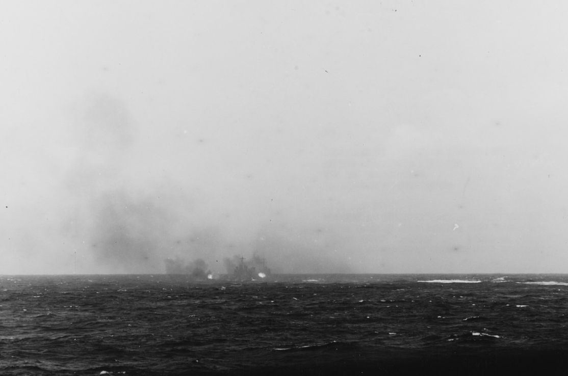 Nashville fires her 6-inch guns at one of the enemy picket boats, 18 April 1942. Photographed from Salt Lake City. (Naval History and Heritage Command Photograph NH 97500)