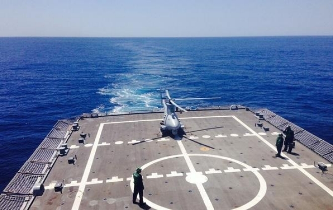 An MQ-8B Fire Scout parks on Freedom’s flight deck while sailors of HSM-35 carry out the first combined at sea operations between unmanned Fire Scouts and manned SH-60 Seahawks, off San Diego, 30 April 2014. (NavAir News Release PEO (U&W) Public Affairs, 1 May 2014)