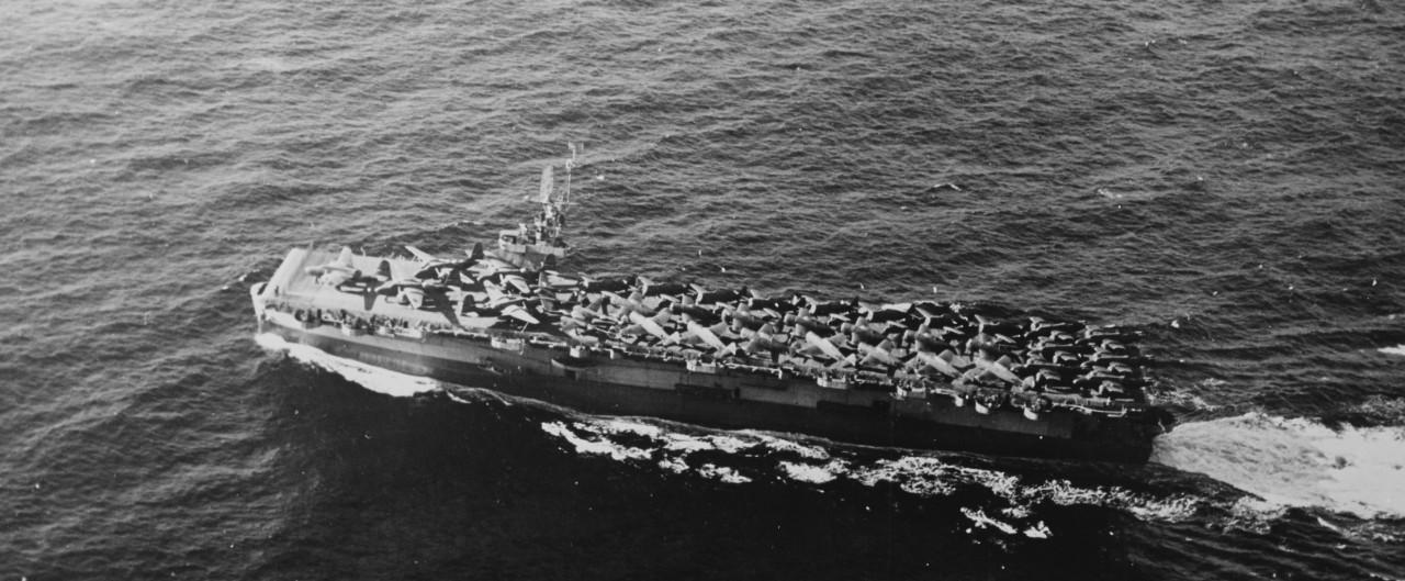 An overhead view of Fanshaw Bay during the shakedown cruise shows her cleanly knifing through the waves, her flight deck packed with USAAF P-47 Thunderbolts, P-38 Lightnings, and A-20 Havocs, January–February 1944. (U.S. Navy Photograph 80-G-2140...